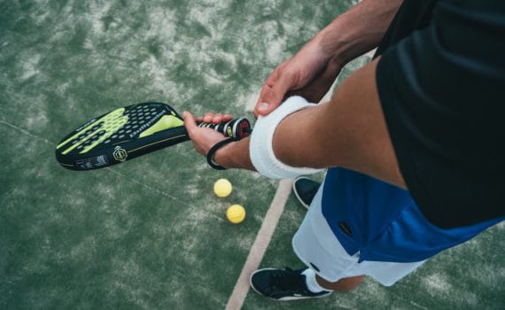 common sports injuries, man holding tennis racket