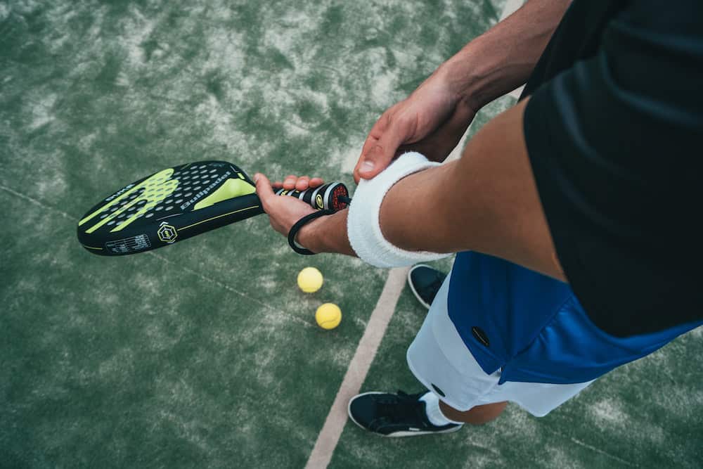 common sports injuries, man holding tennis racket