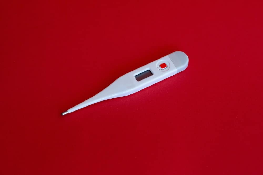 thermometer on red background for flu season during covid-19