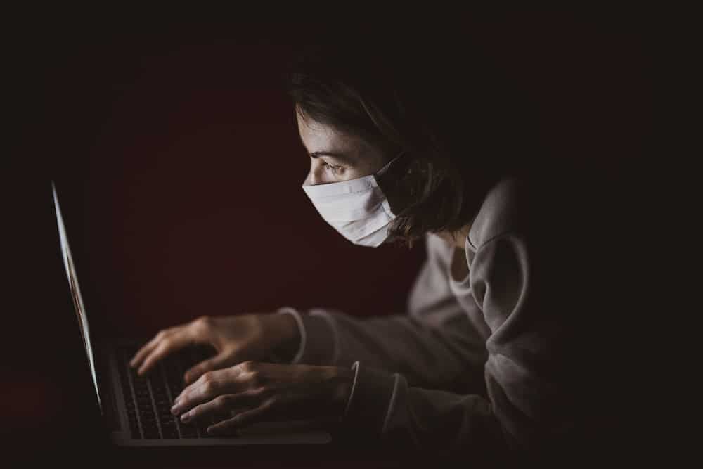 woman searching covid-19 symptoms sore throat on laptop